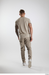 Gilbert 1 back view dressed grey t-shirt grey trousers walking…